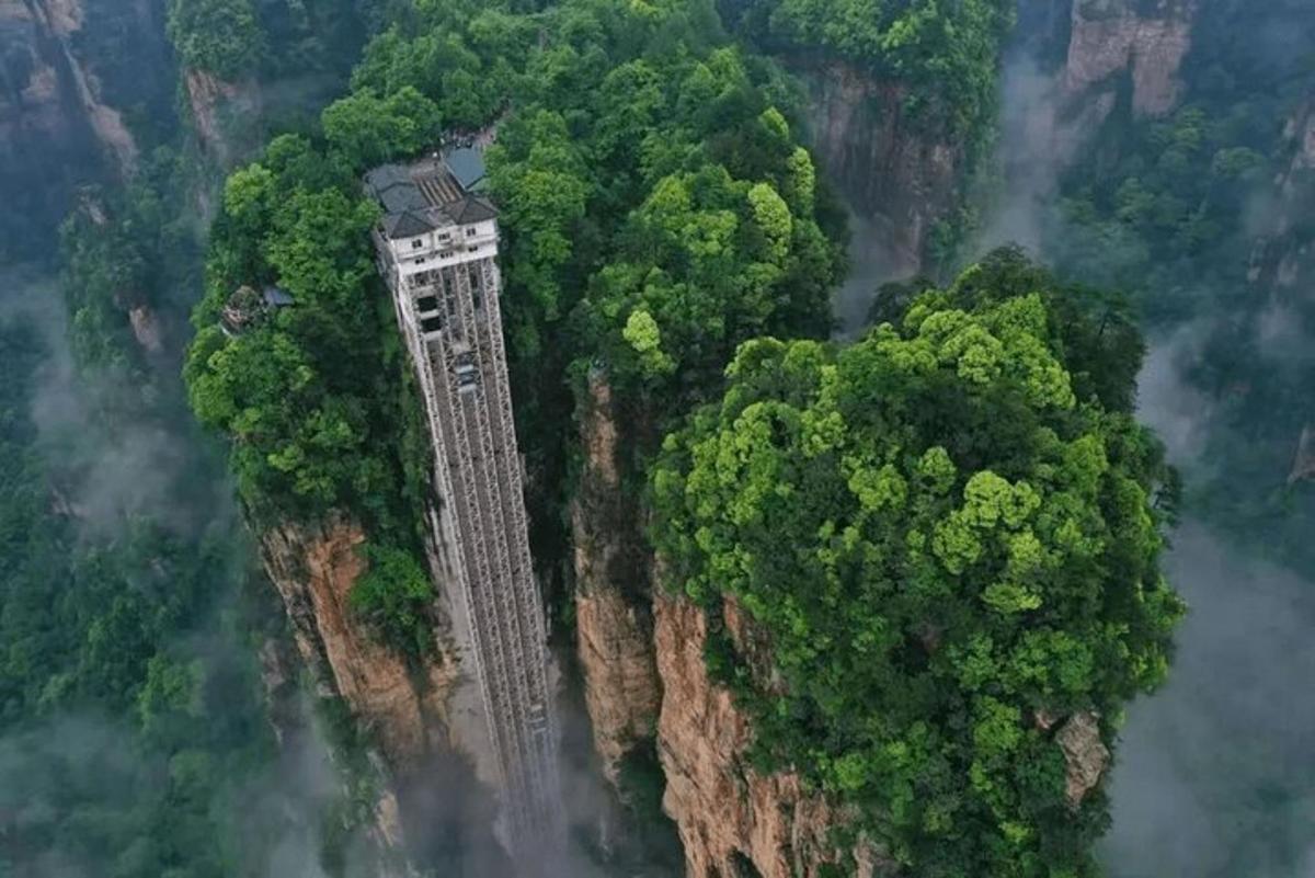 a building on the side of a mountain with trees