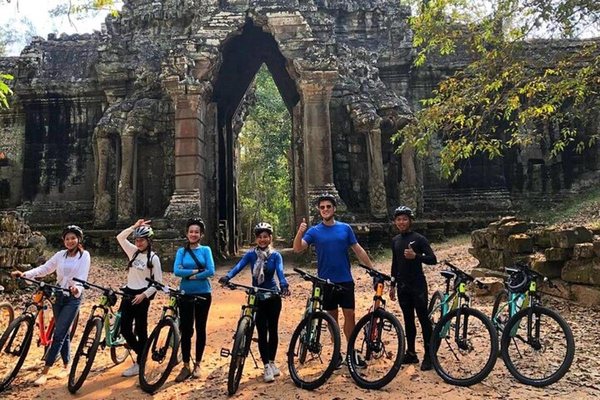 un gruppo di persone con le biciclette davanti a un edificio