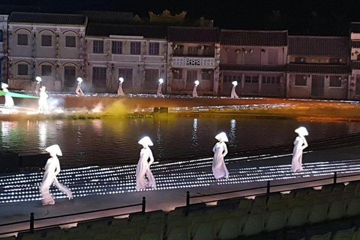 Un grupo de mujeres caminando por un río por la noche.
