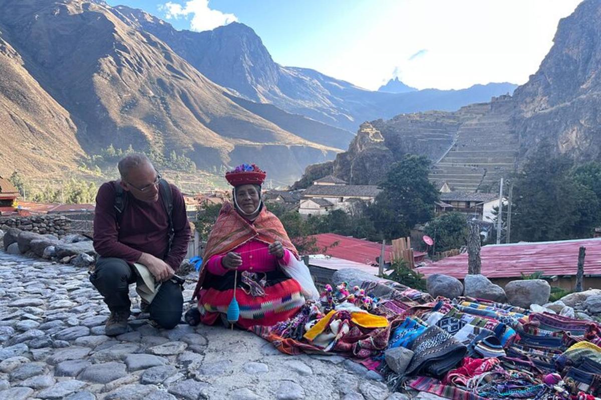 a man and a woman sitting next to a pile of clothing