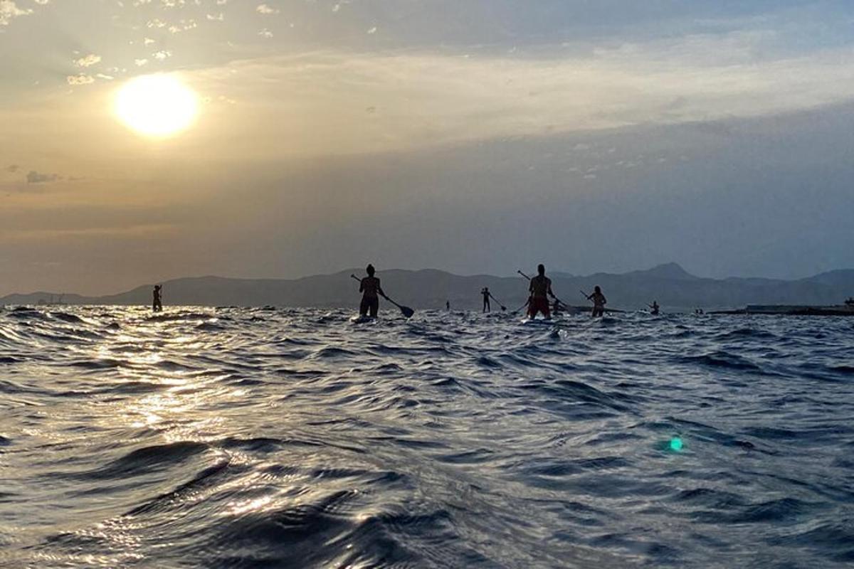 a group of people on a paddle board in the ocean