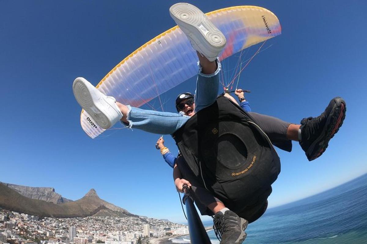 zwei Menschen fliegen mit einem Fallschirm über den Ozean