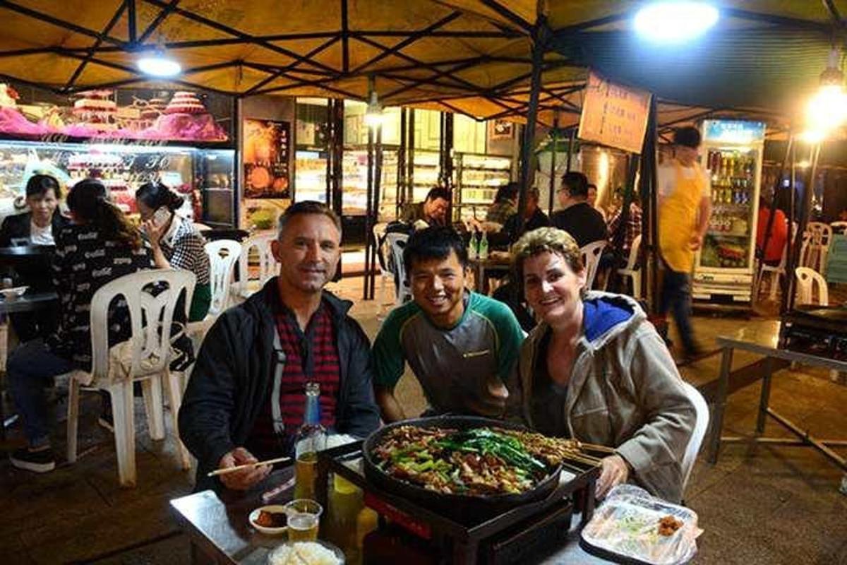 三个男人坐在桌旁，托盘上放着食物