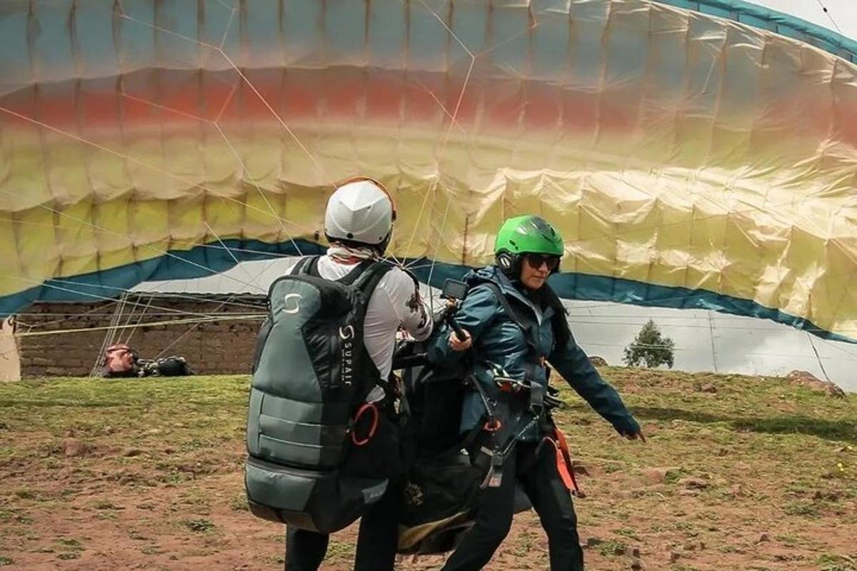 duas pessoas estão em pé ao lado de um grande paraquedas