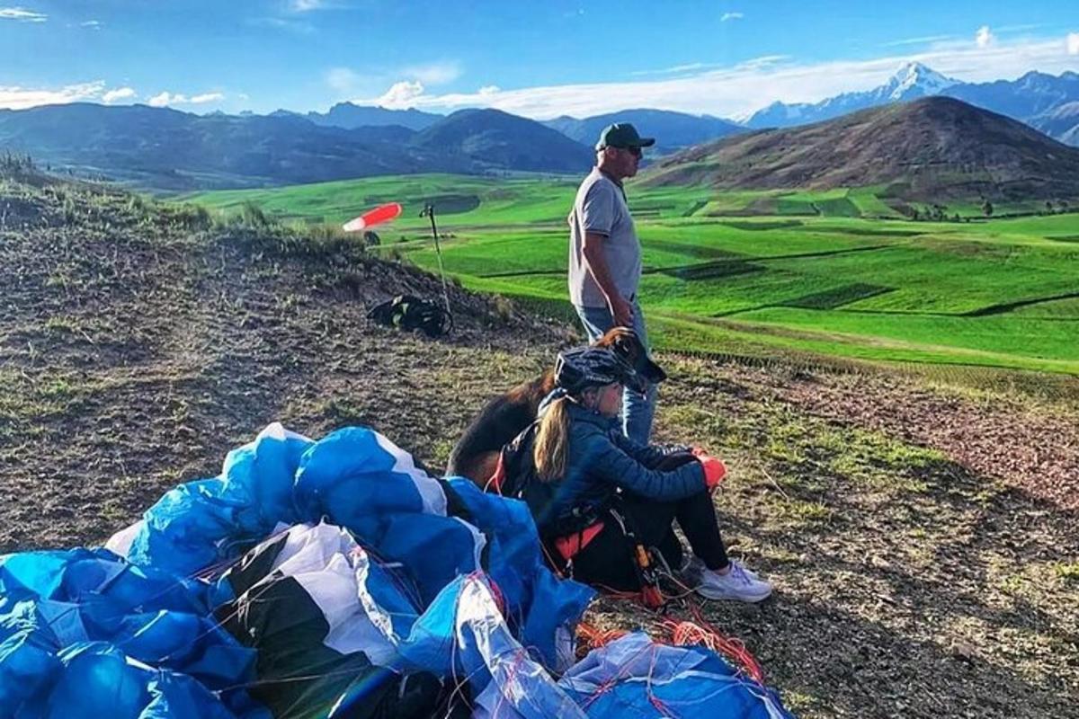 um homem em pé no topo de uma colina com tendas