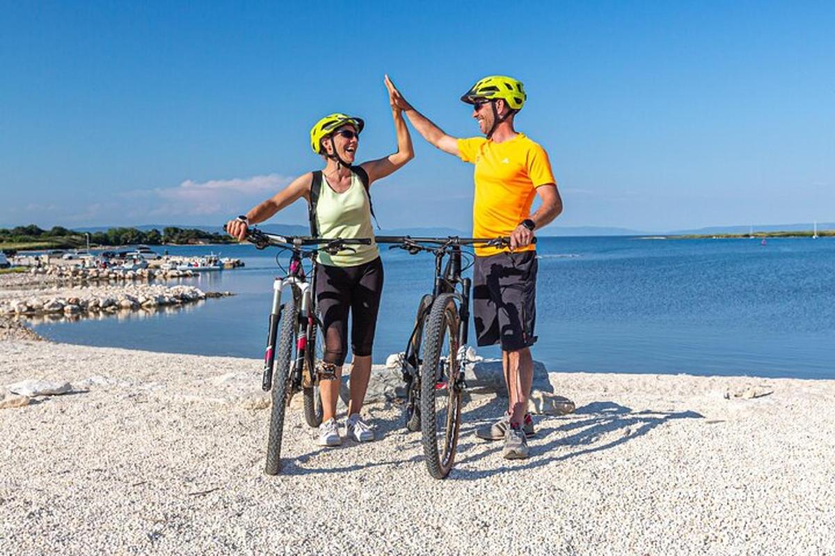 um homem e uma mulher com bicicletas na praia