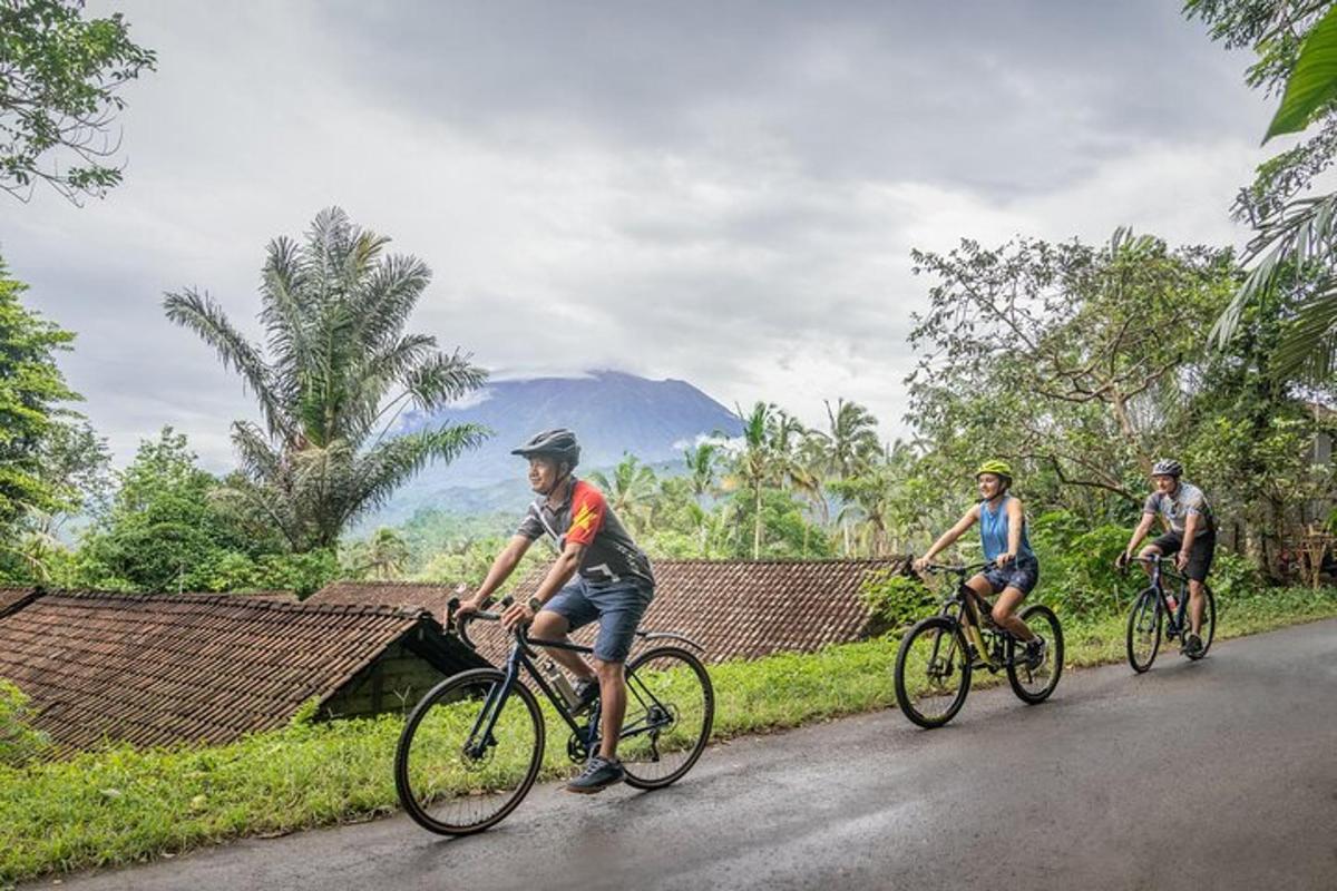 três pessoas andando de bicicleta em uma estrada