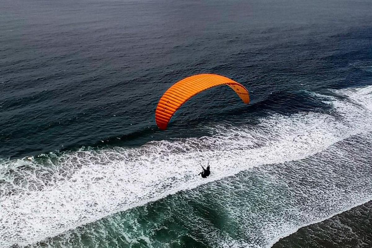 a person riding a kite over the ocean