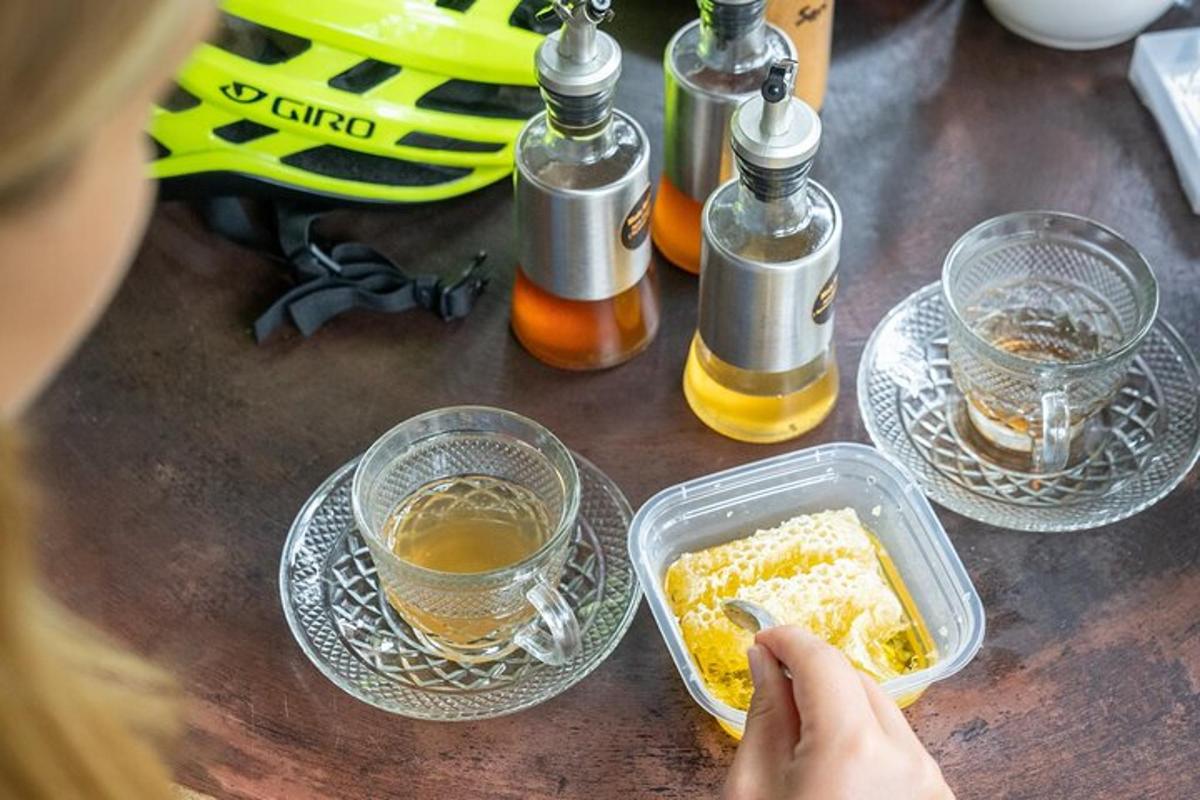 un tavolo con bottiglie di miele e un contenitore di cibo