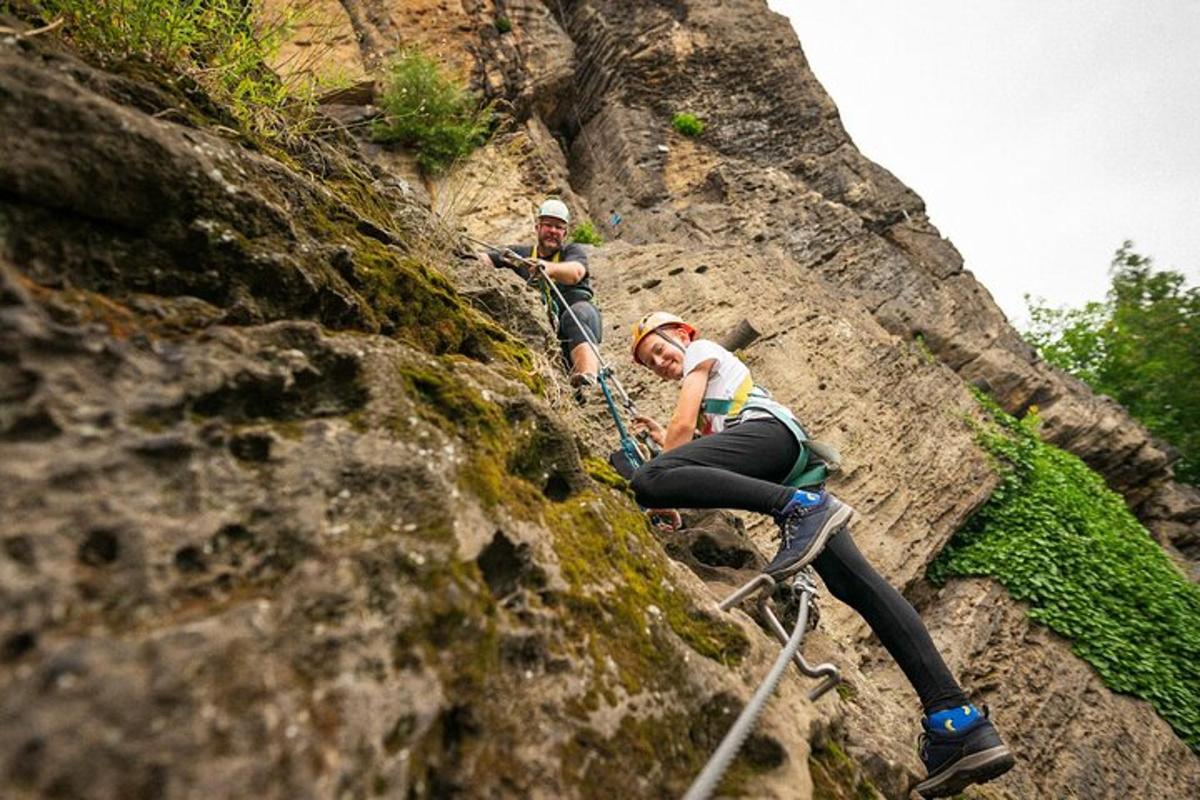 dos personas escalando una pared de roca