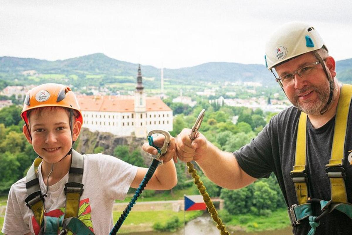 Un hombre y un niño con cascos en la cima de una torre