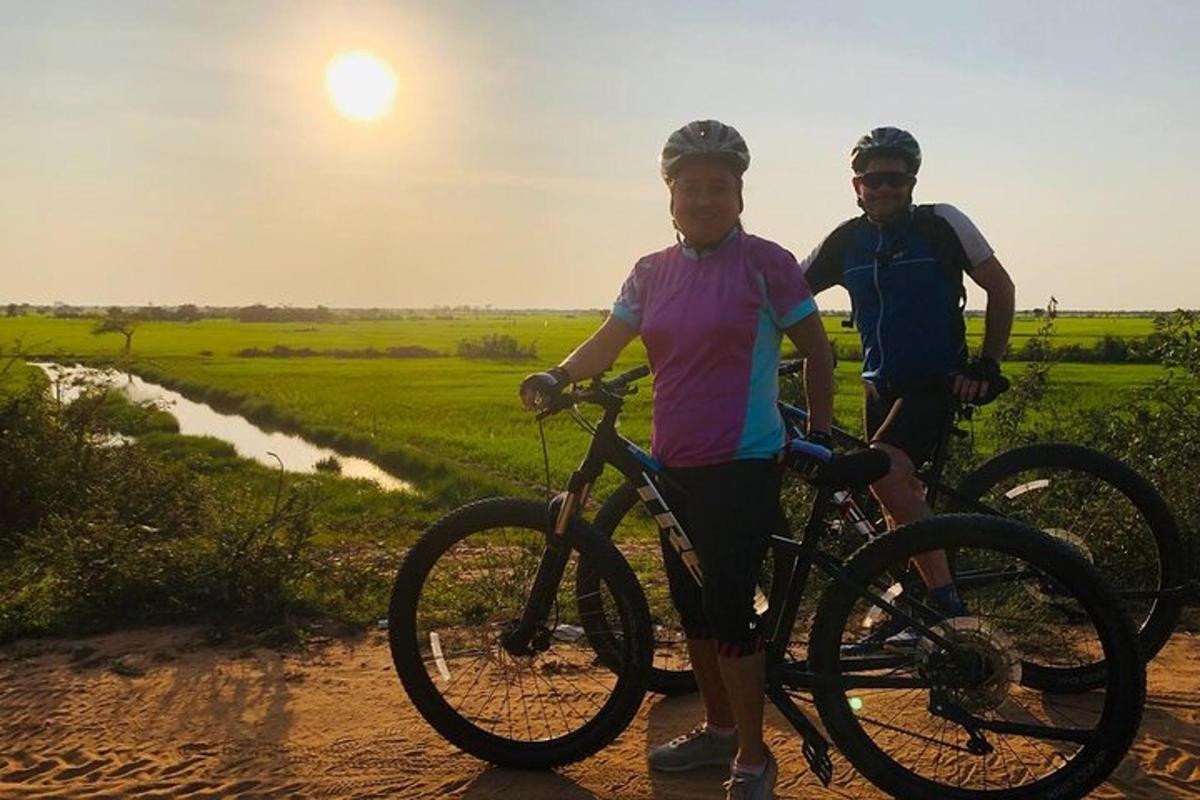 un home i una dona drets amb bicicletes en un camí de terra