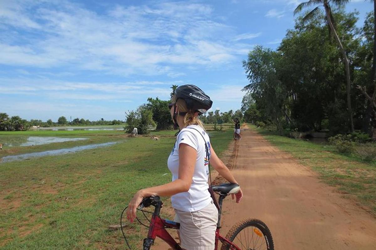 una dona anant en bicicleta per un camí de terra