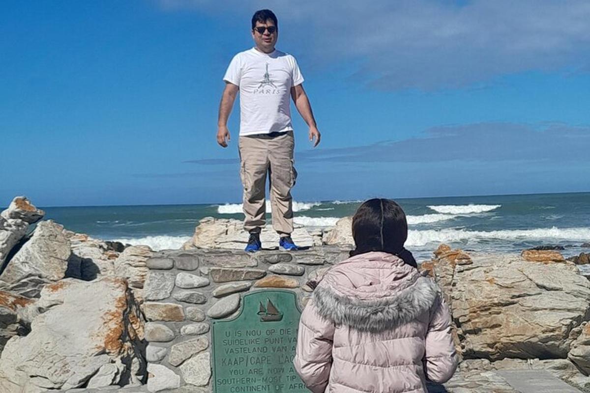 en man som står på en klippvägg nära havet