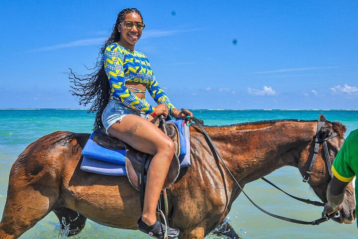 uma mulher cavalgando na praia