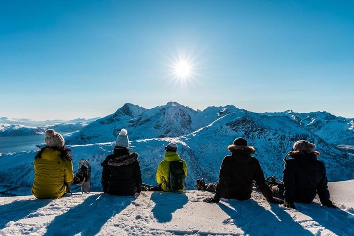 a group of people sitting on top of a snow covered mountain