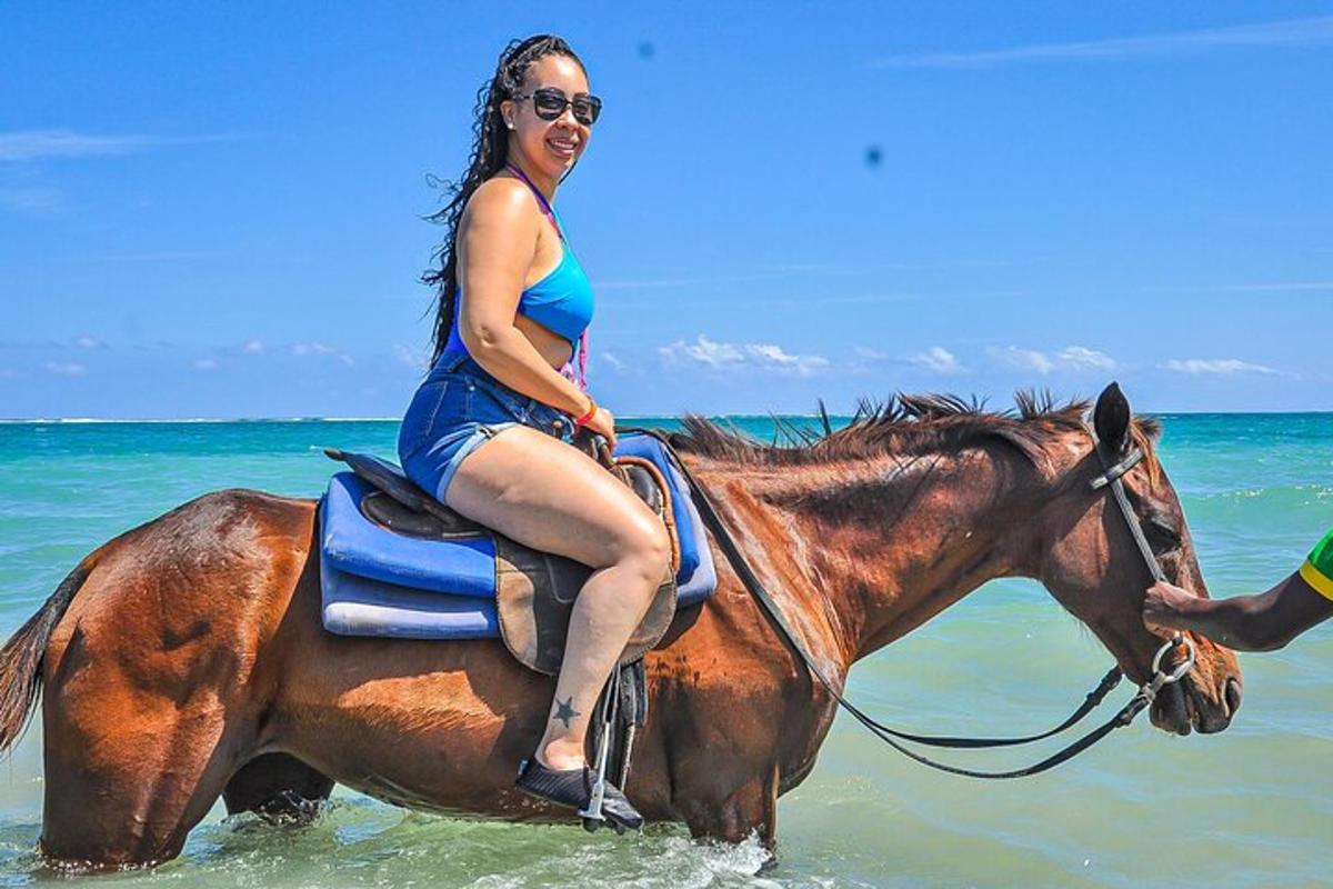 uma mulher cavalgando um cavalo no oceano