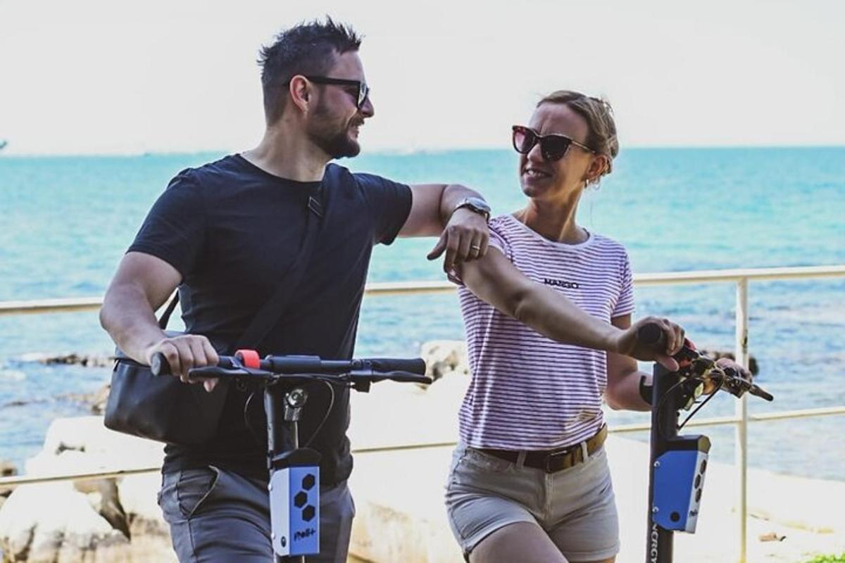 a man and a woman riding a bike on the beach