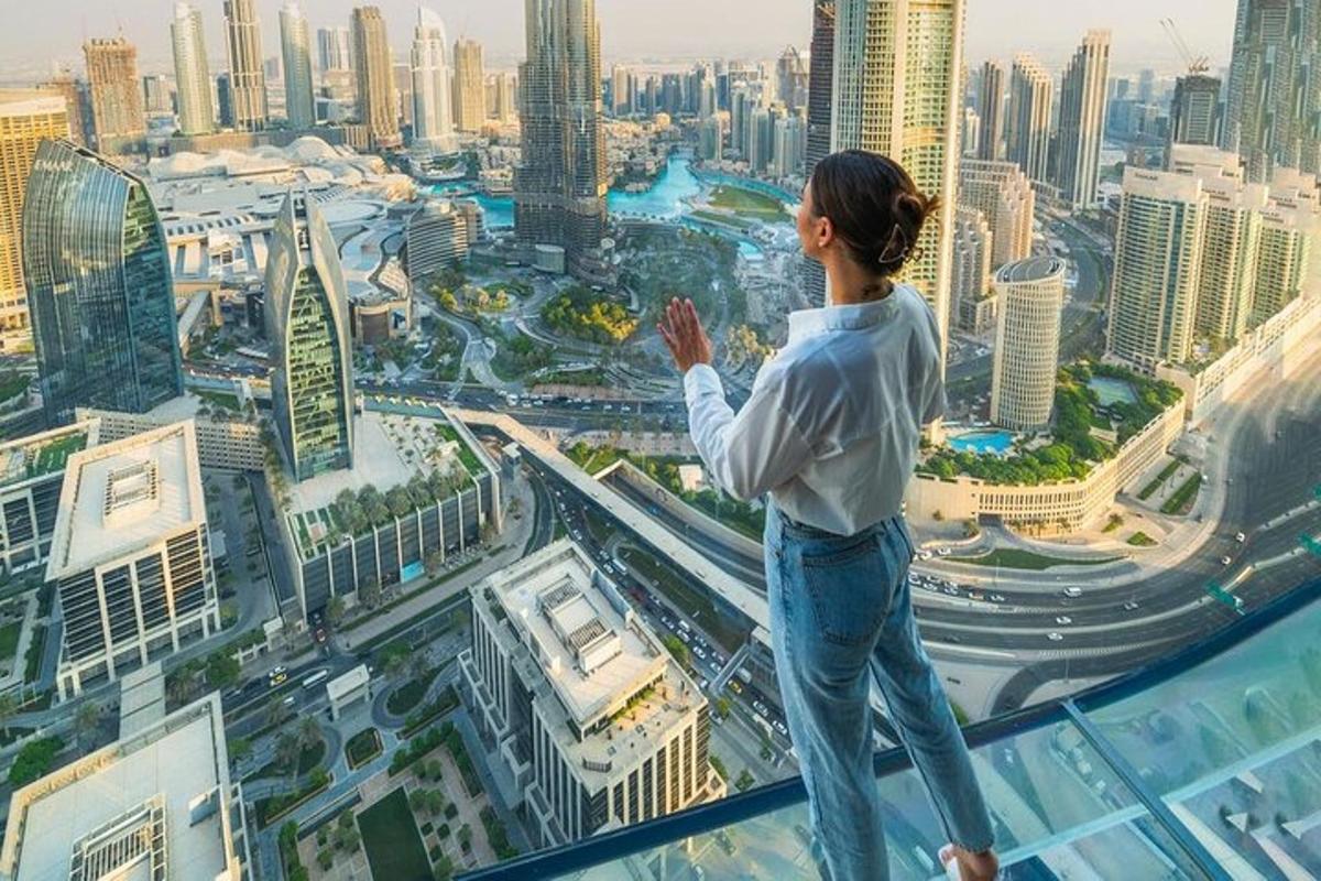 một người phụ nữ đứng trên đỉnh một tòa nhà chọc trời nhìn xuống thành phố