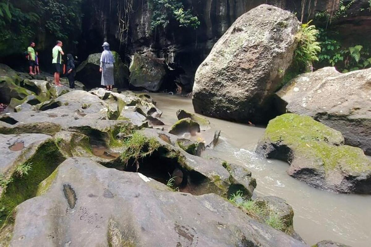 eine Gruppe von Menschen steht in einem Fluss mit Steinen