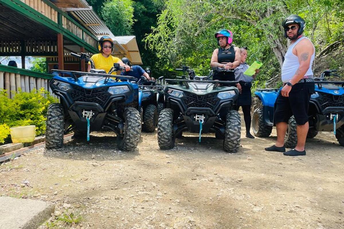 tiga orang berdiri di sebelah empat atv