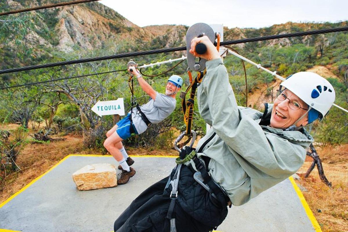 two people on a zip line in the mountains