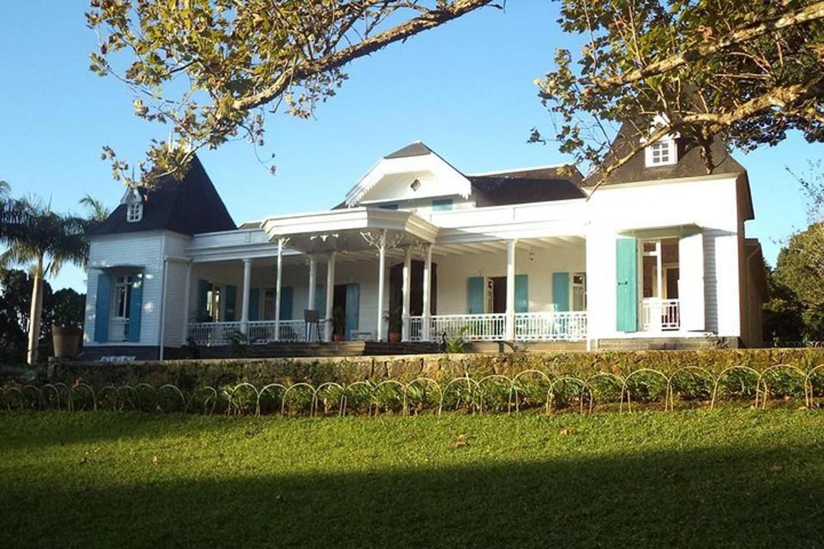 una grande casa bianca con un prato davanti