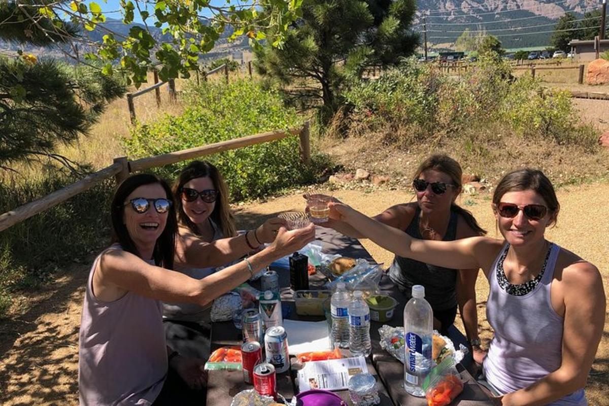 eine Gruppe von Frauen sitzt an einem Tisch und hält ein Glas hoch