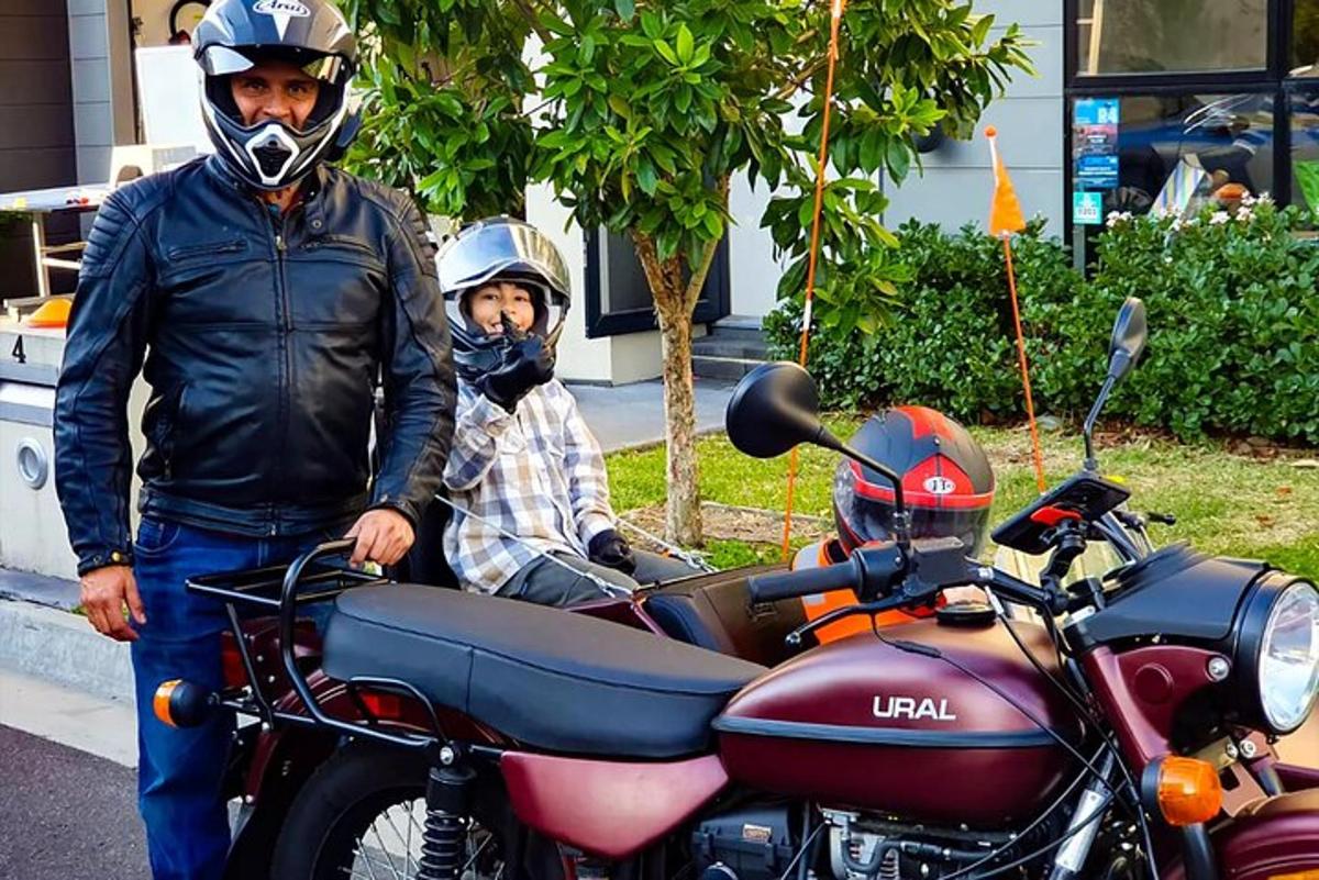 due uomini che indossano il casco in piedi accanto a una motocicletta