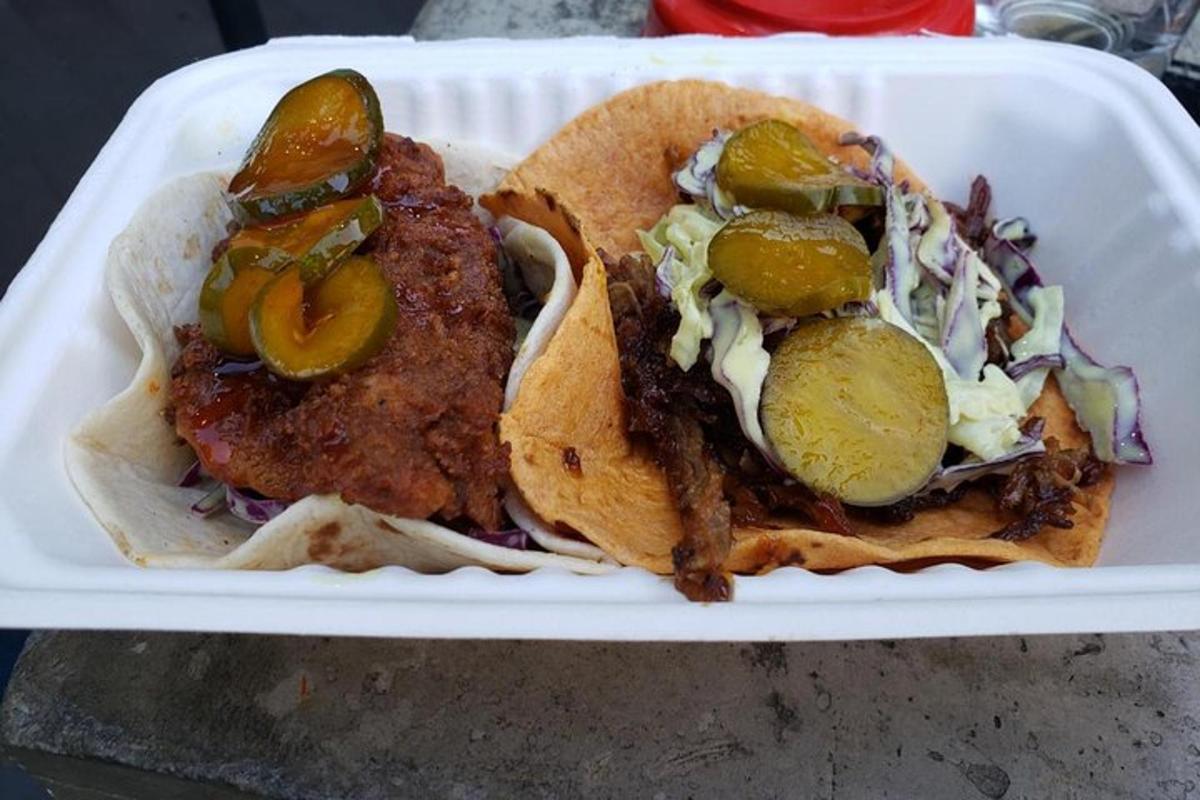 un vassoio bianco con due tacos con sottaceti e cipolle