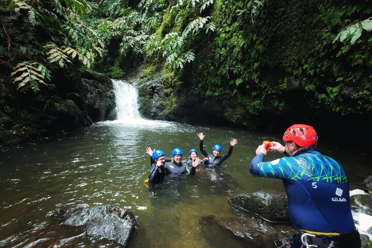 eine Gruppe von Menschen im Wasser vor einem Wasserfall