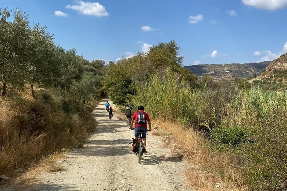 a group of people riding bikes down a dirt road