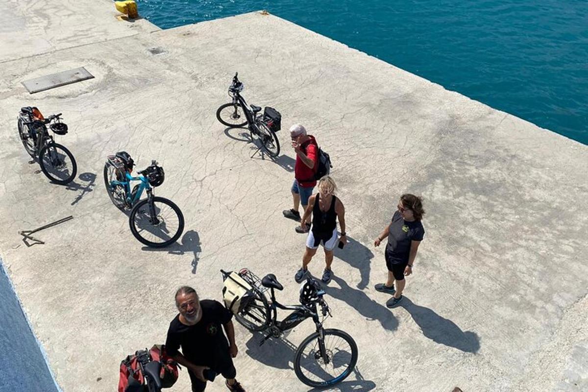 a group of people walking their bikes on a pier