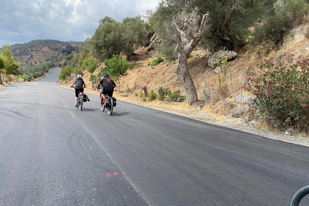 two people riding their bikes down a road