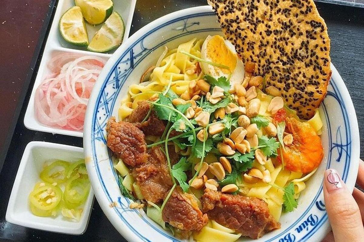 a bowl of food with pasta and a sandwich