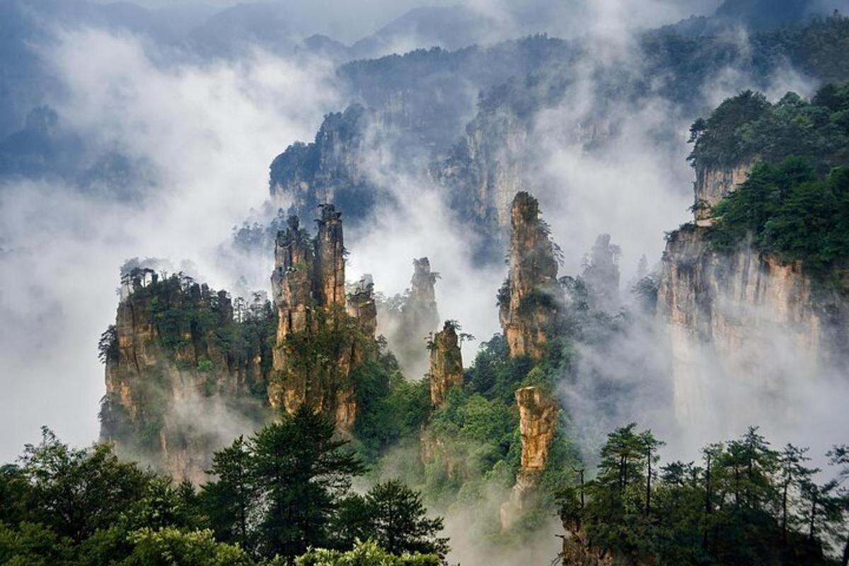 a view of a mountain range with clouds and trees
