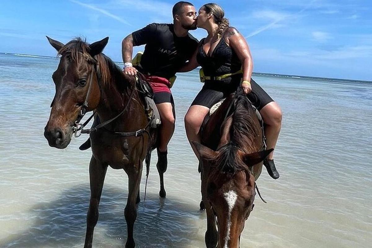 seorang lelaki dan wanita menunggang kuda di pantai