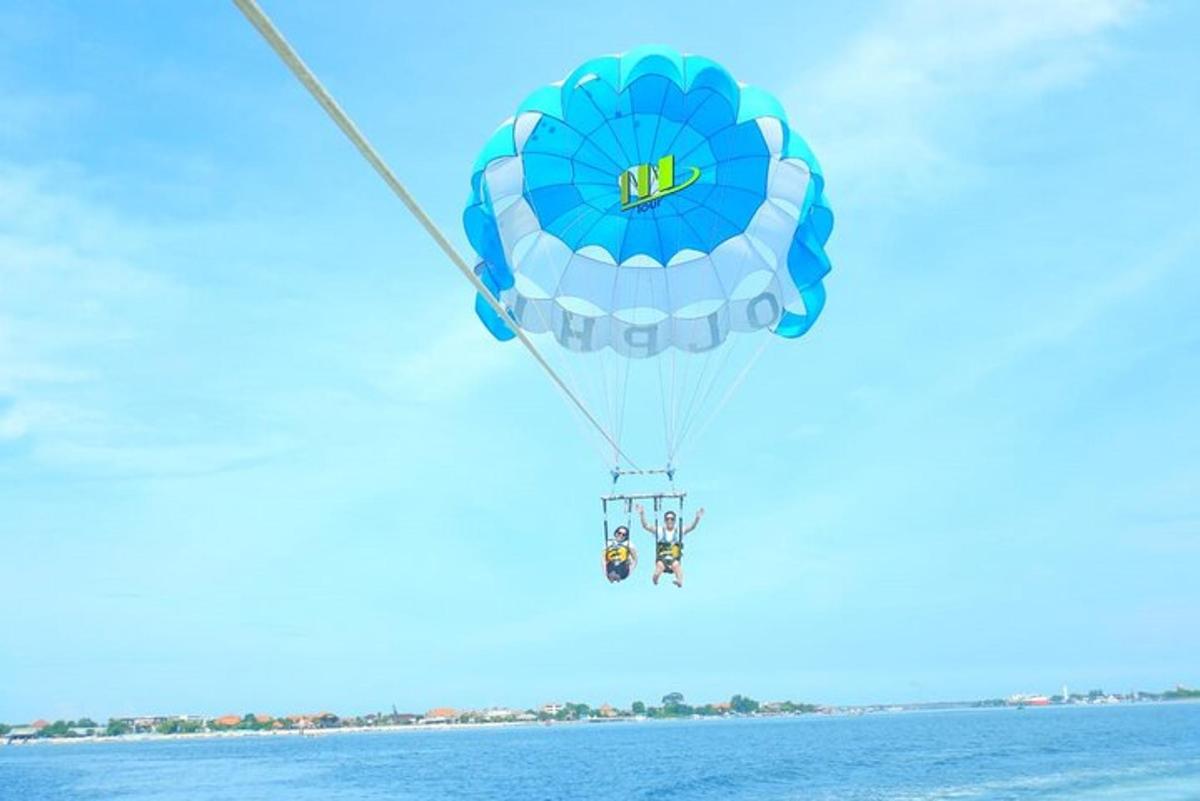 modrý horkovzdušný balón letící nad vodou