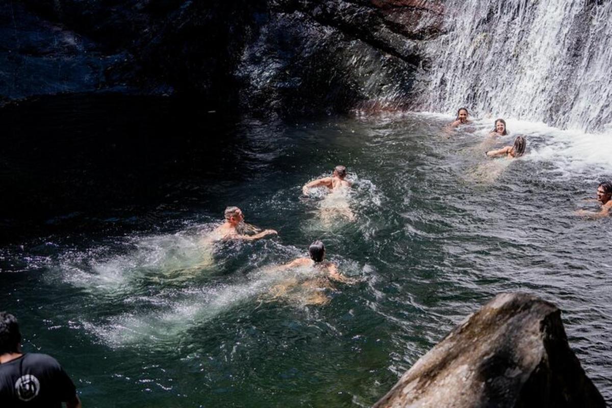 eine Gruppe von Menschen, die in einem Wasserfall schwimmen