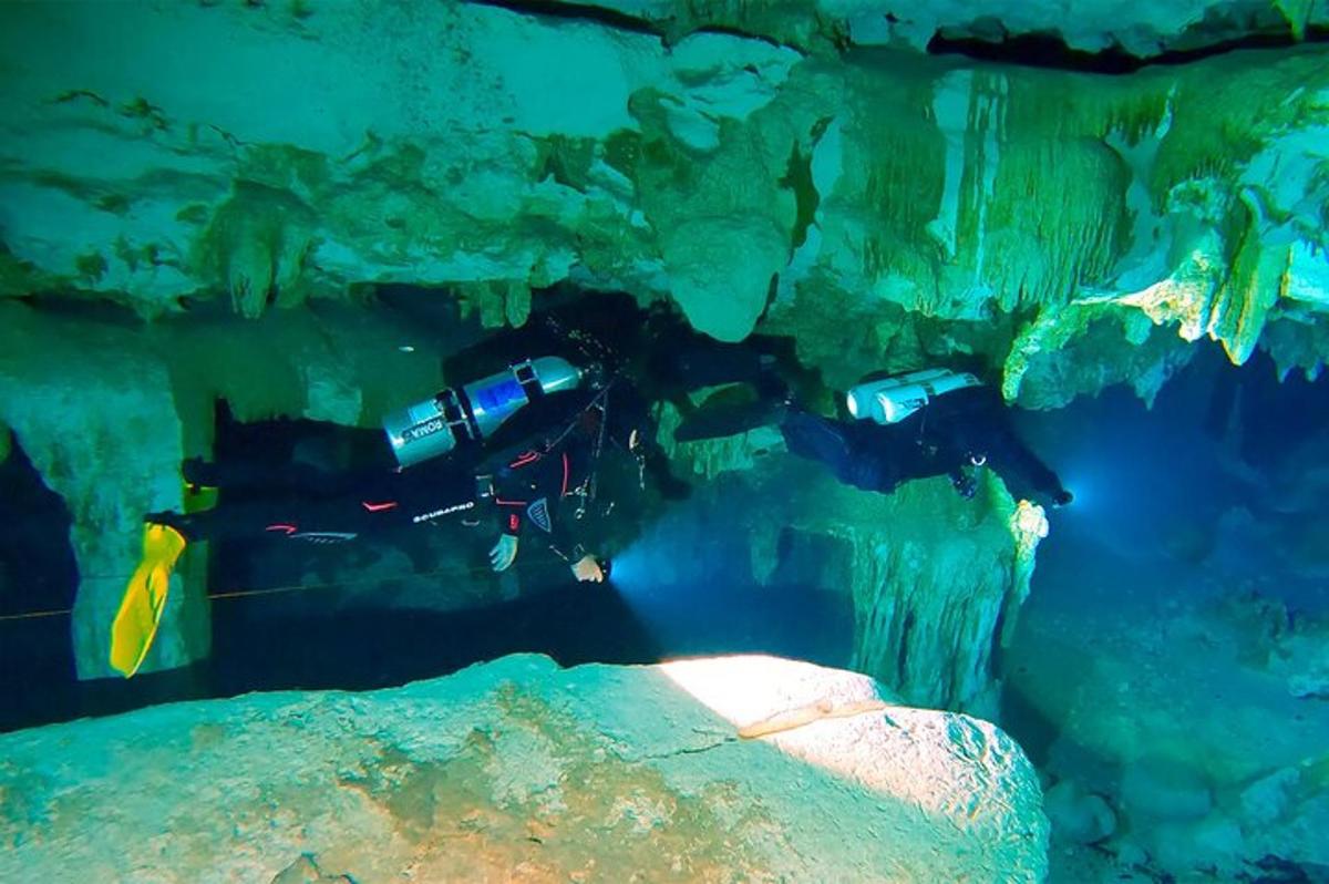 a group of people swimming in a cave