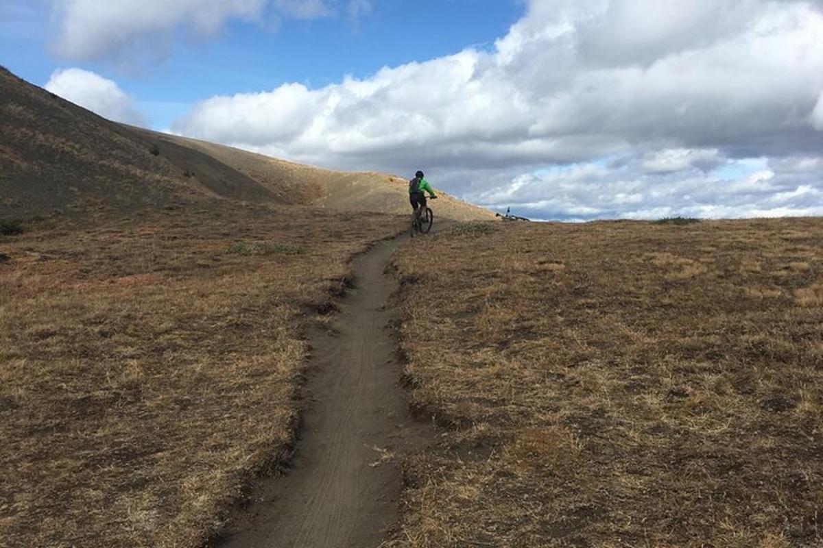 a person riding a bike down a dirt road
