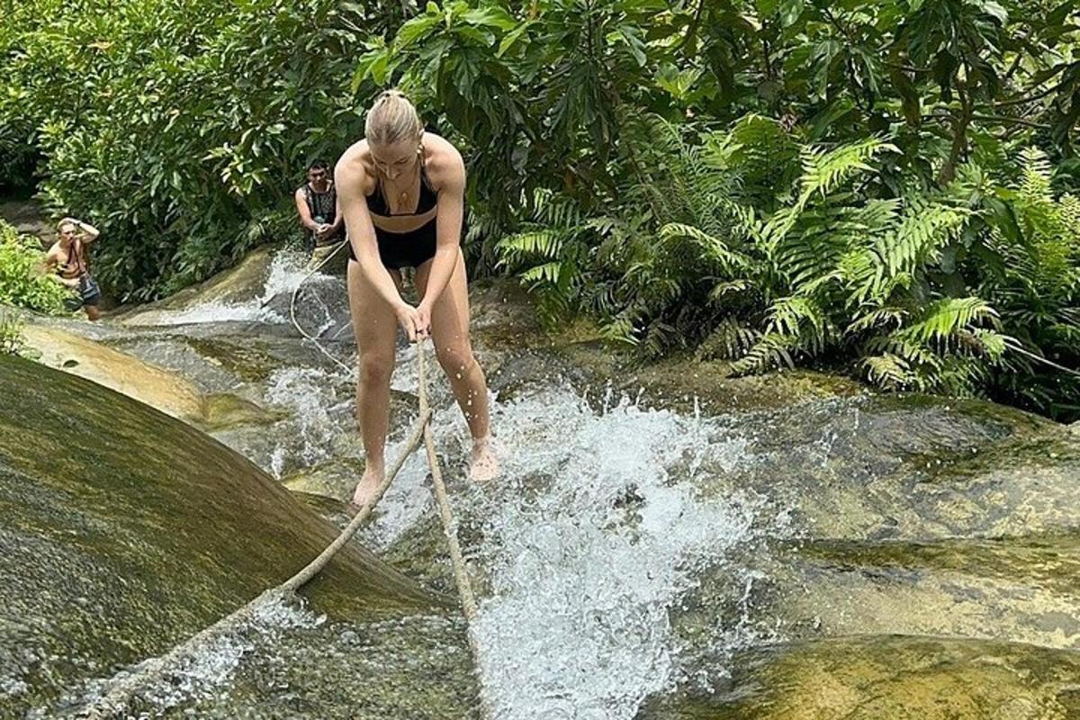 a woman is standing on a rope in a river