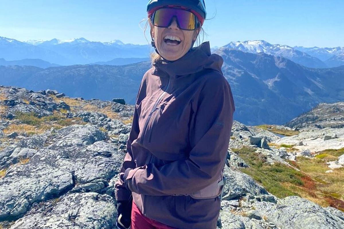 a woman standing on the top of a mountain