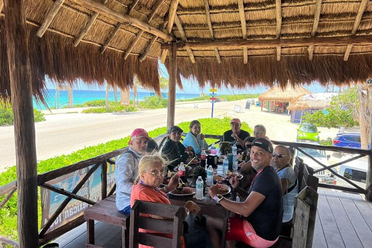 un grup de oameni așezați la o masă pe plajă