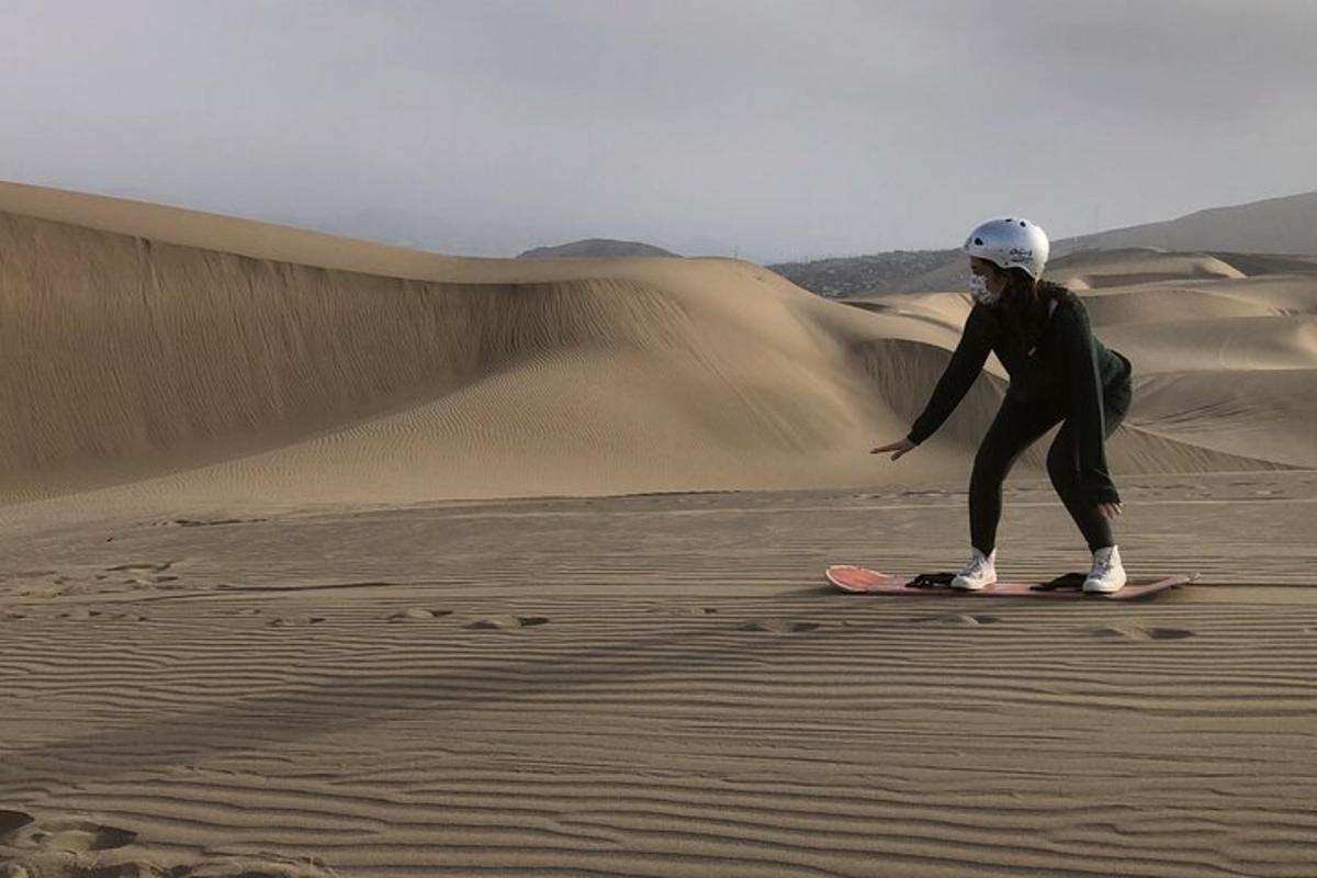Una persona parada en una tabla de snowboard en el desierto.