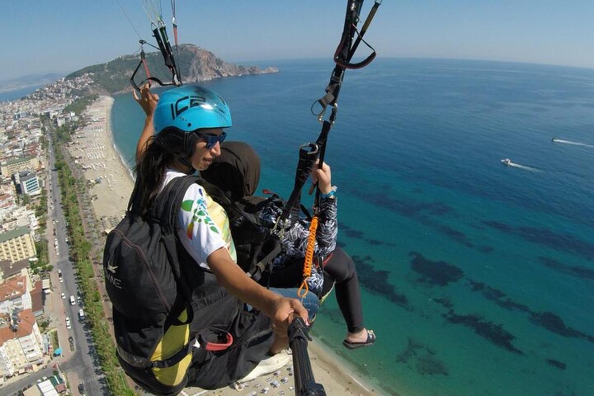 dalawang tao sa isang zip line sa ibabaw ng karagatan