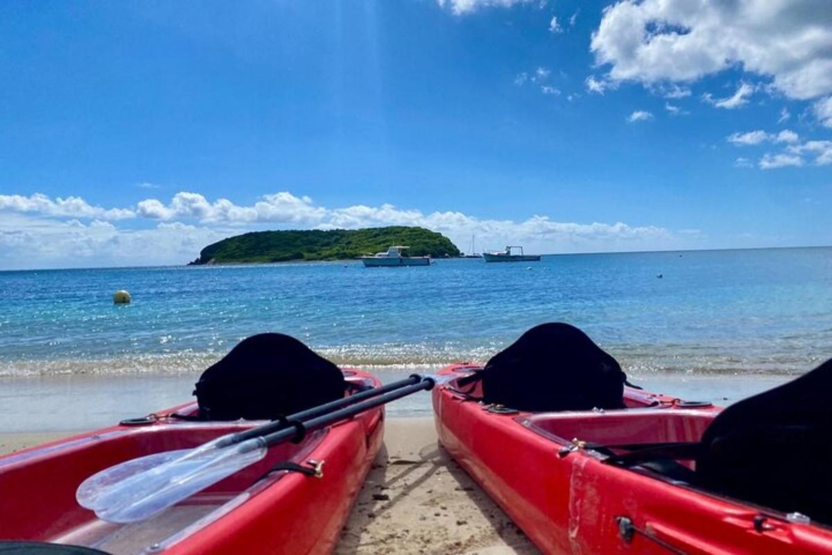 Dos barcos rojos en la playa con una isla en el agua