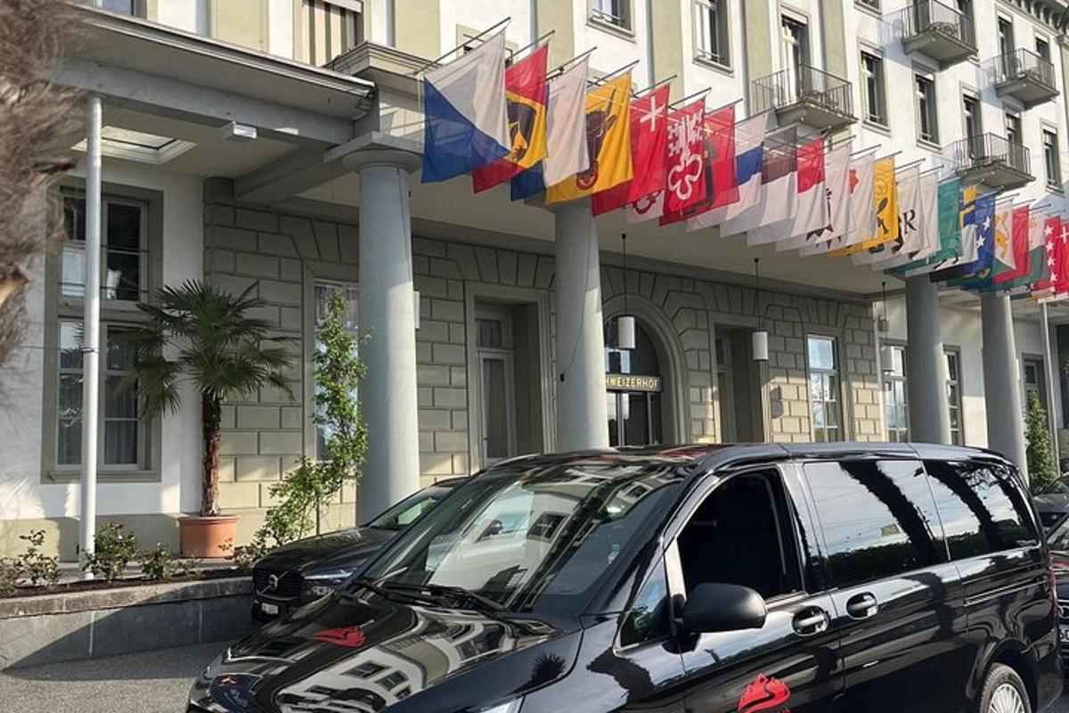 auto zaparkované pred budovou s vlajkami