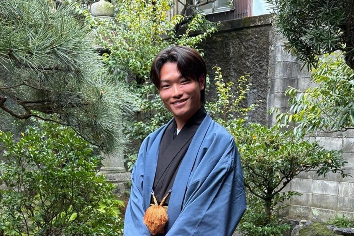 着物を着て手に植物を持っている男性