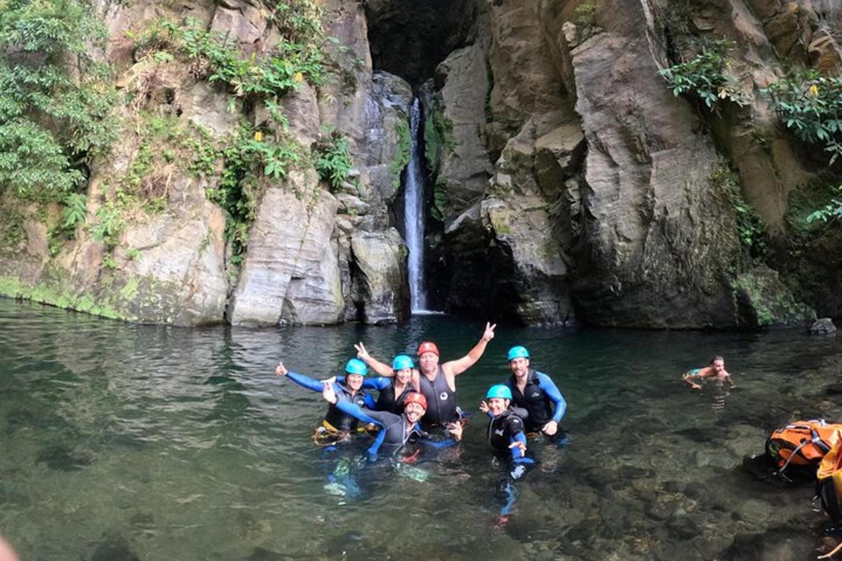 Un grupo de personas en el agua frente a una cascada.